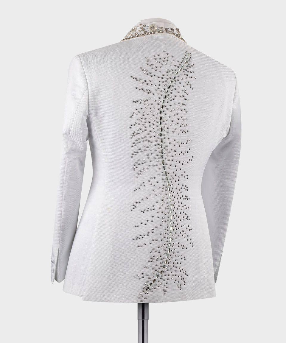 White long-sleeve blazer shown from the back on a mannequin, featuring a vertical line of silver rhinestones down the center back and a rhinestone-trimmed collar.
