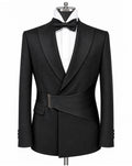 A black formal tuxedo jacket with peak lapels and a wrap-style waist belt, displayed on a mannequin torso with a white dress shirt and black bow tie against a plain white background.