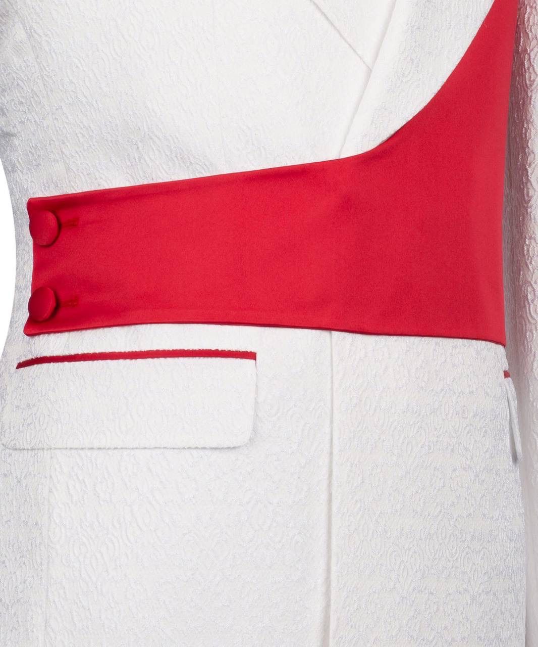 Close-up of a white garment with a red accent and button