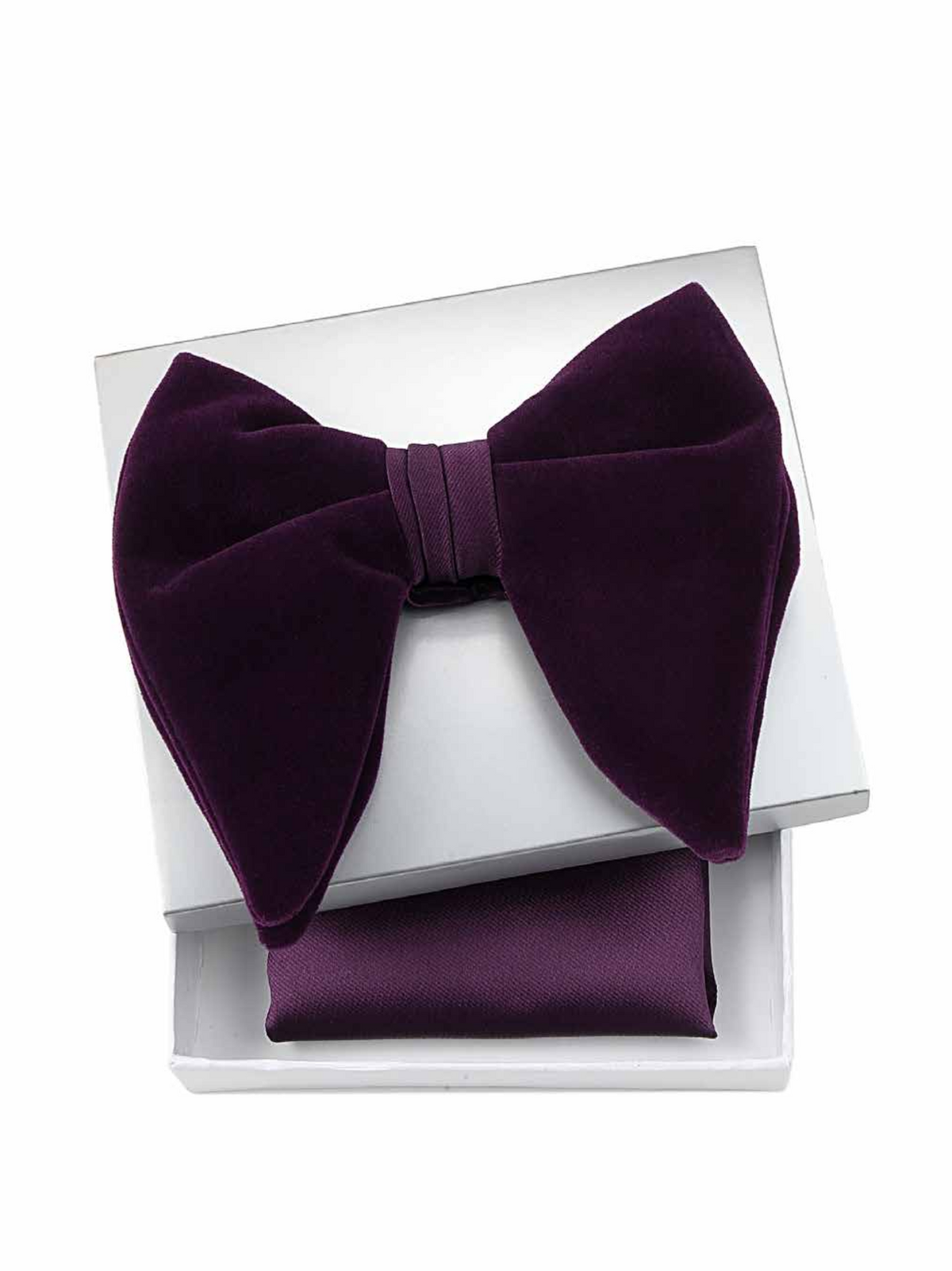 A deep purple velvet bow tie displayed on top of a matching folded purple pocket square inside an open white gift box, set against a plain white background.