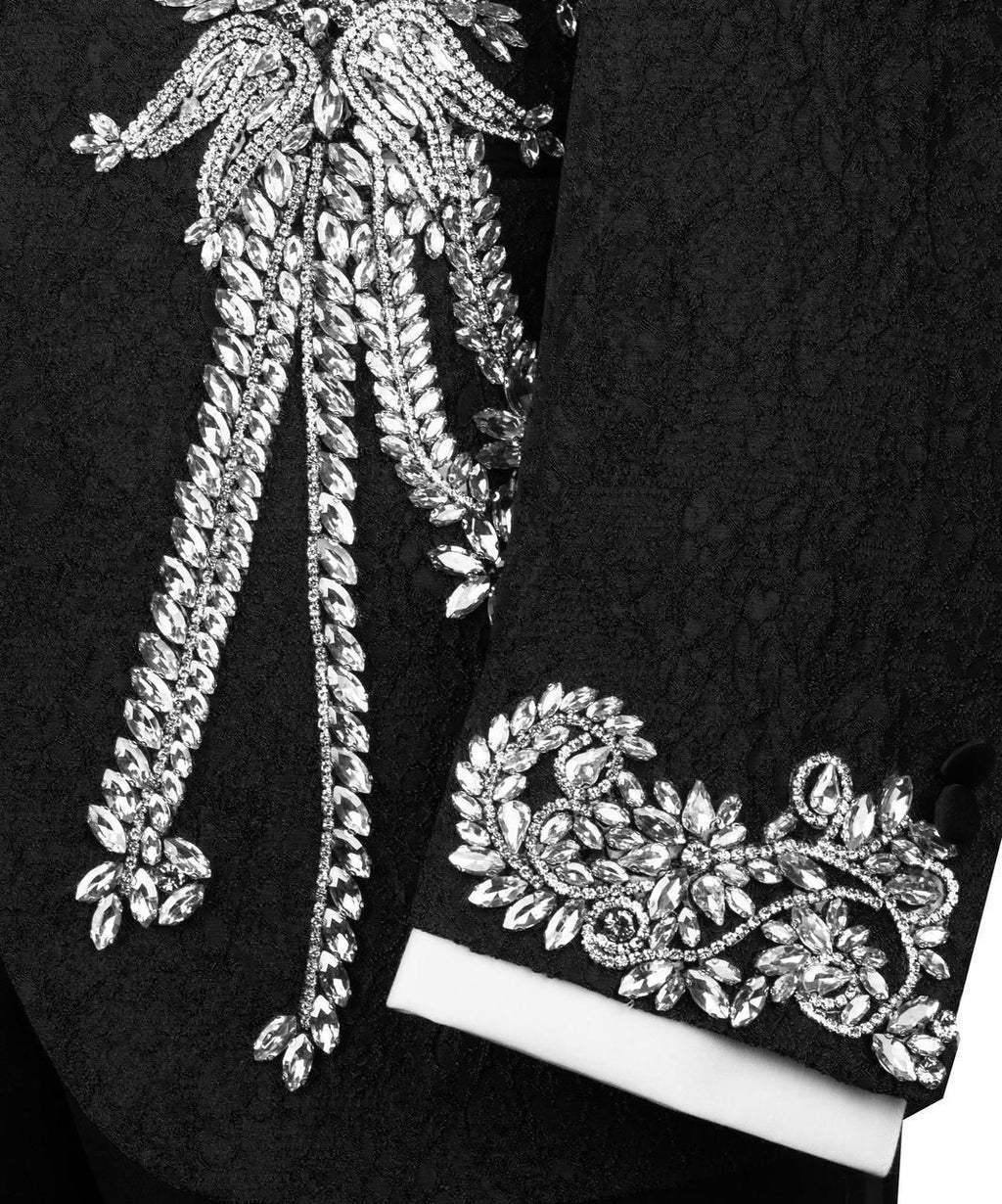 Close-up of decorative silver embroidery on a black fabric background