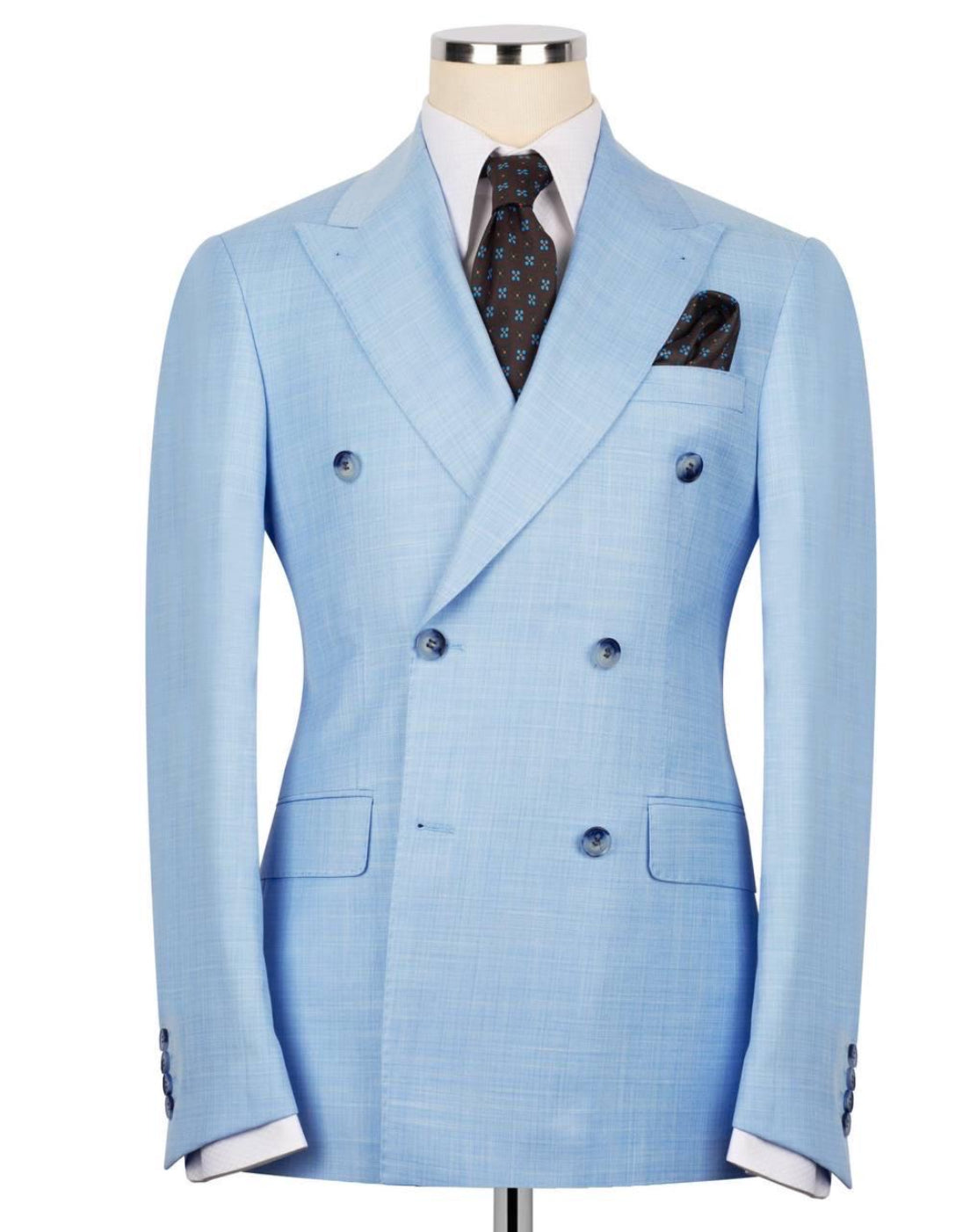 A light blue double-breasted suit jacket displayed on a mannequin torso, styled with a white dress shirt, a dark patterned tie, and a matching pocket square against a plain white background.