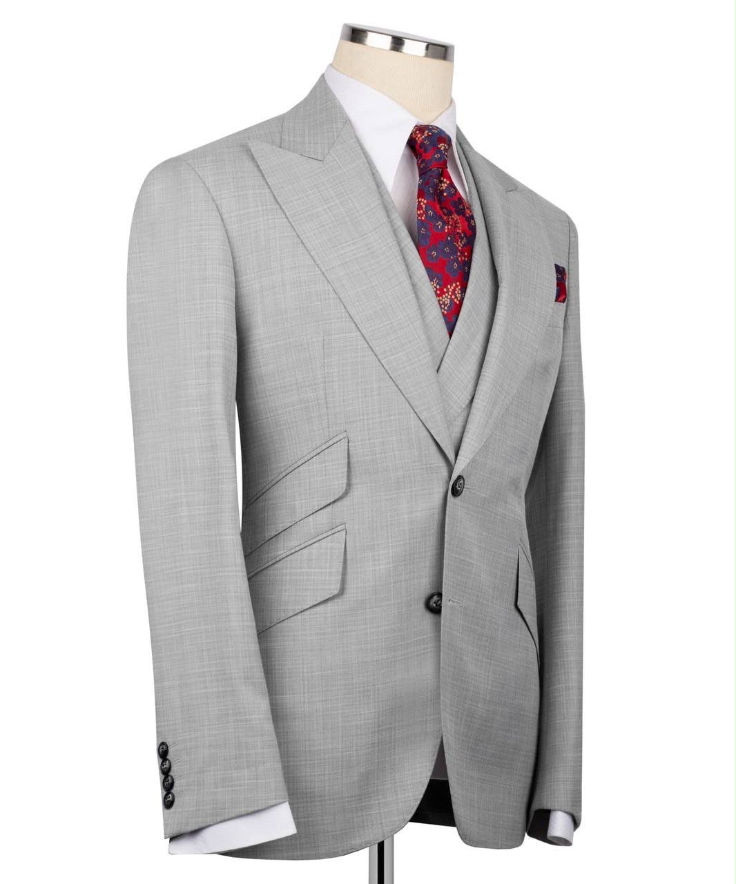 Gray suit jacket on a mannequin with a patterned tie and pocket square against a white background