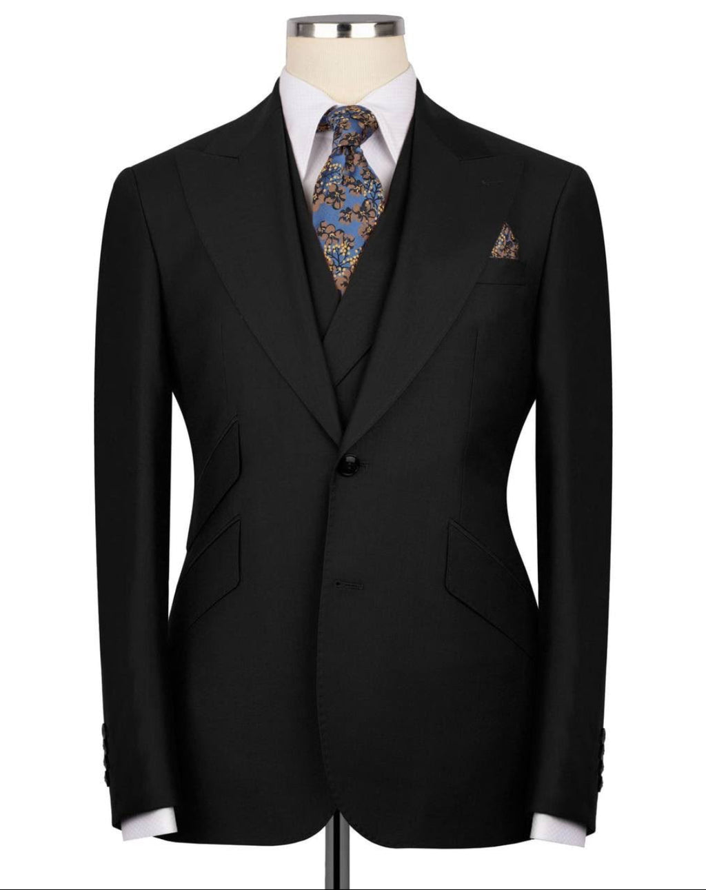 Black suit jacket on a mannequin with a patterned tie and pocket square against a white background