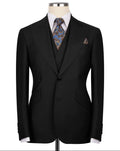 Black suit jacket on a mannequin with a patterned tie and pocket square against a white background