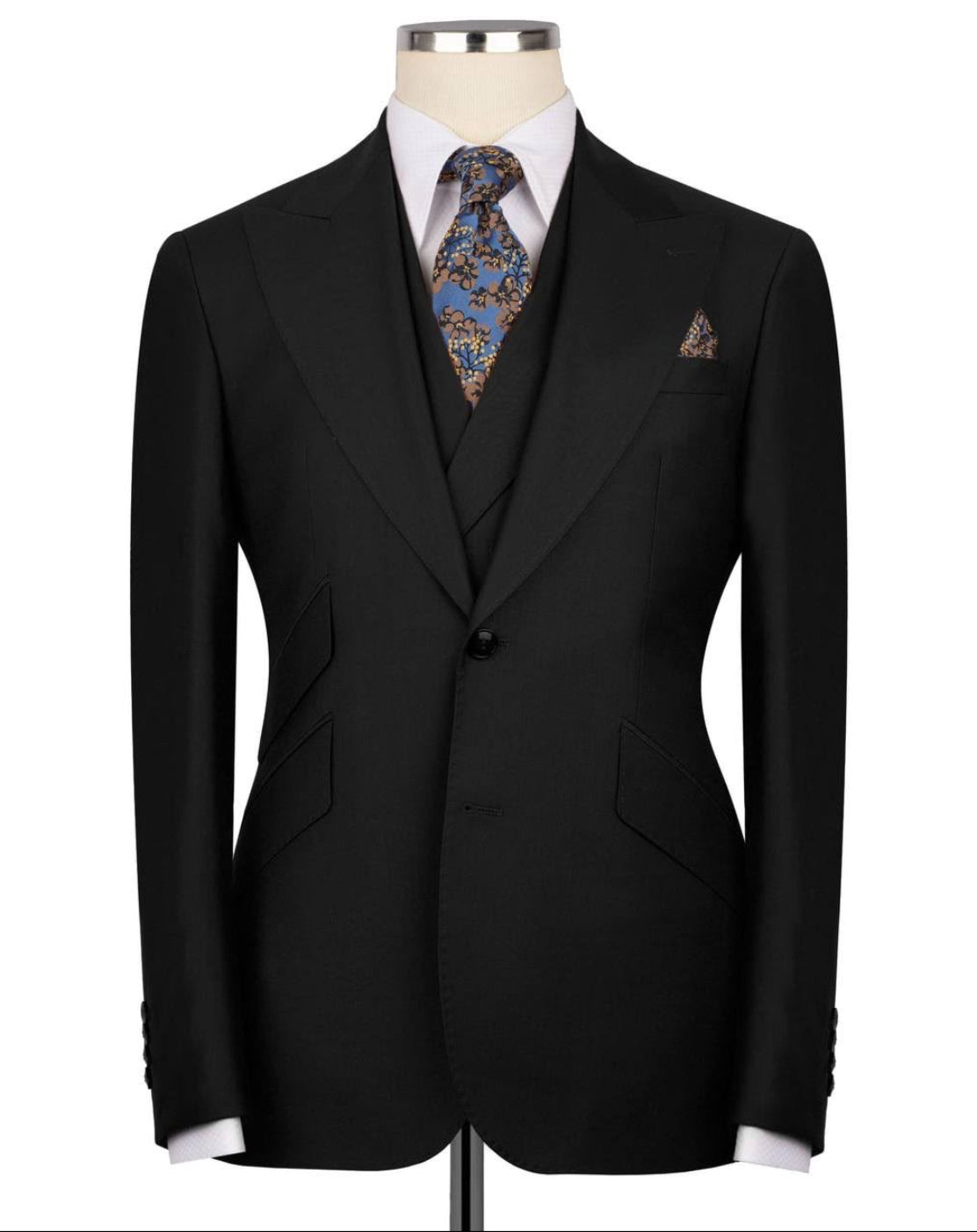 Black suit jacket on a mannequin with a patterned tie and pocket square against a white background