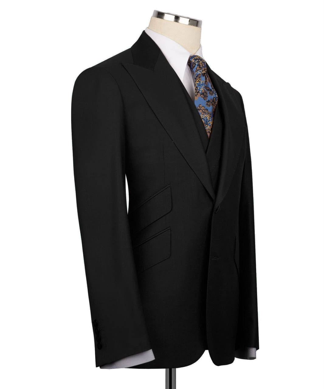 A black men's suit jacket displayed on a mannequin torso with a white dress shirt and a blue paisley patterned tie, set against a plain white background.