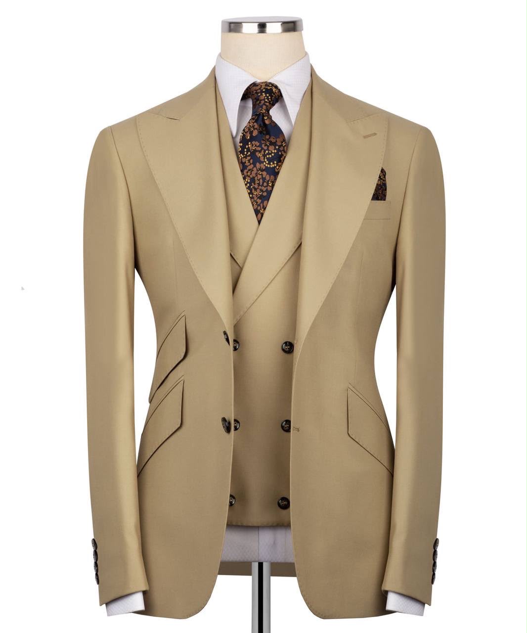 A beige double-breasted suit jacket with matching vest, styled on a mannequin with a white dress shirt and a patterned tie.