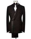 A black double-breasted tuxedo jacket displayed on a mannequin torso, styled with a black bow tie, white dress shirt, and matching black trousers