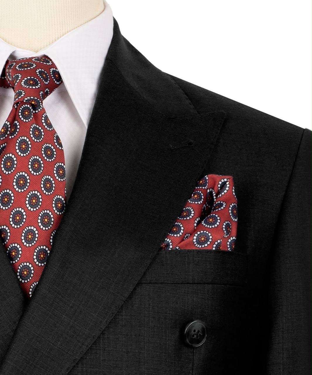 Black suit with red patterned tie and pocket square on a mannequin