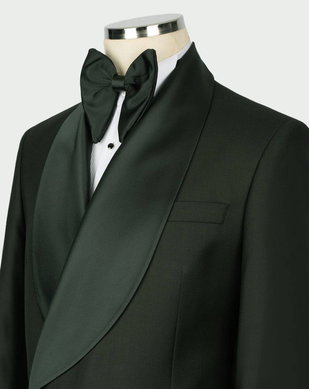 A dark green formal tuxedo jacket with satin peak lapels, styled on a mannequin with a matching dark green bow tie and white dress shirt.