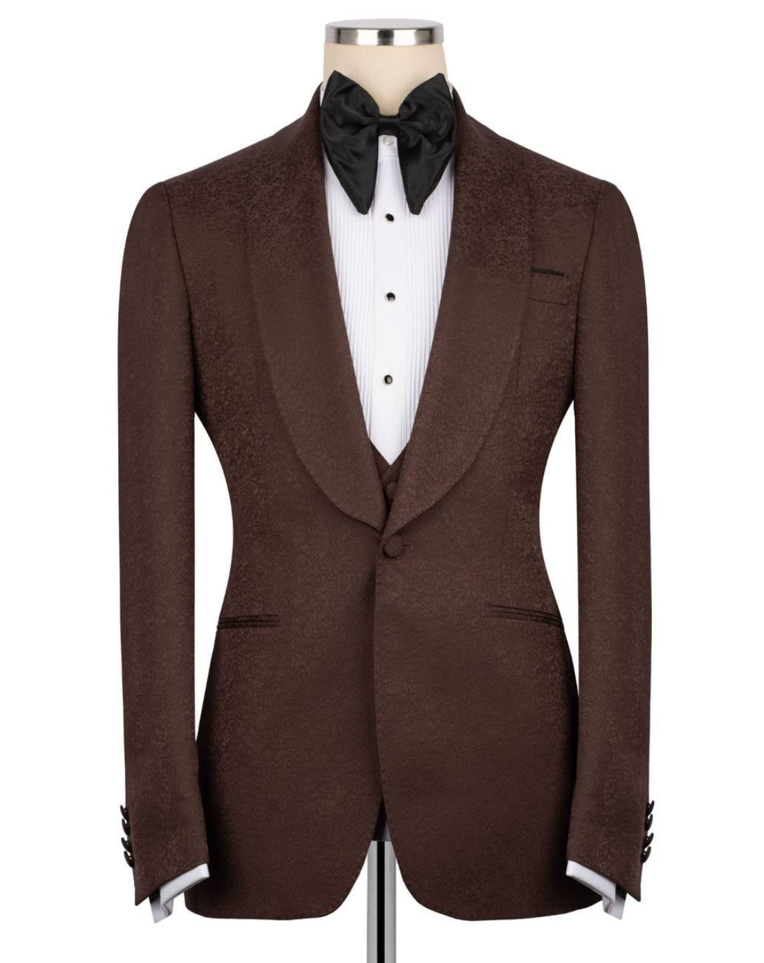 A brown textured tuxedo jacket displayed on a mannequin with a white dress shirt, black bow tie, and black cufflinks, .