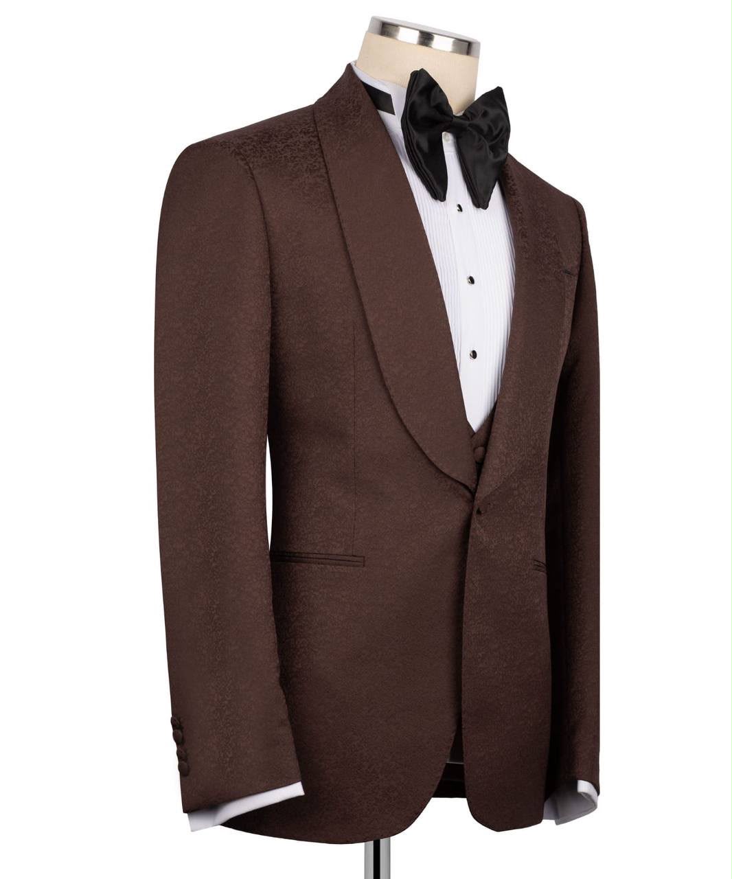A brown tuxedo jacket with satin peak lapels, displayed on a mannequin torso wearing a white dress shirt and black bow tie 