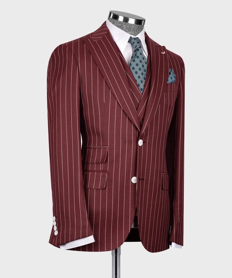 A men's three-piece suit displayed on a mannequin, featuring a burgundy jacket with thin white pinstripes, a matching vest, and trousers, styled with a white dress shirt, a blue patterned tie, and a matching pocket square.