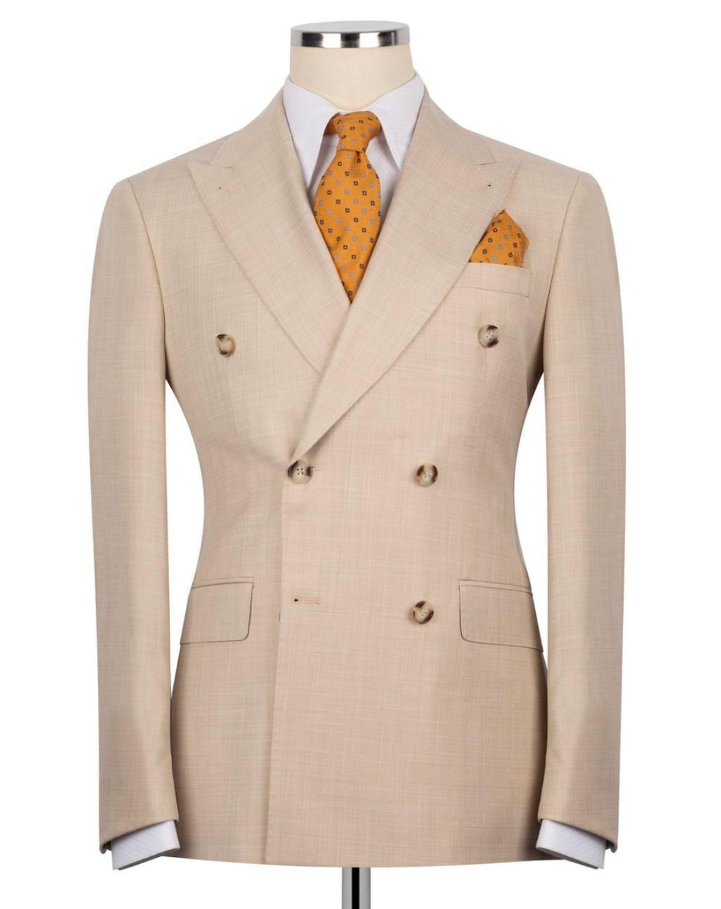 A beige double-breasted suit jacket displayed on a mannequin torso, styled with a white dress shirt, an orange patterned tie, and a matching orange pocket square against a plain white background.
