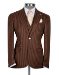A brown pinstripe suit jacket displayed on a mannequin torso, styled with a white dress shirt, a light beige patterned tie, and a matching pocket square against a light gray background.