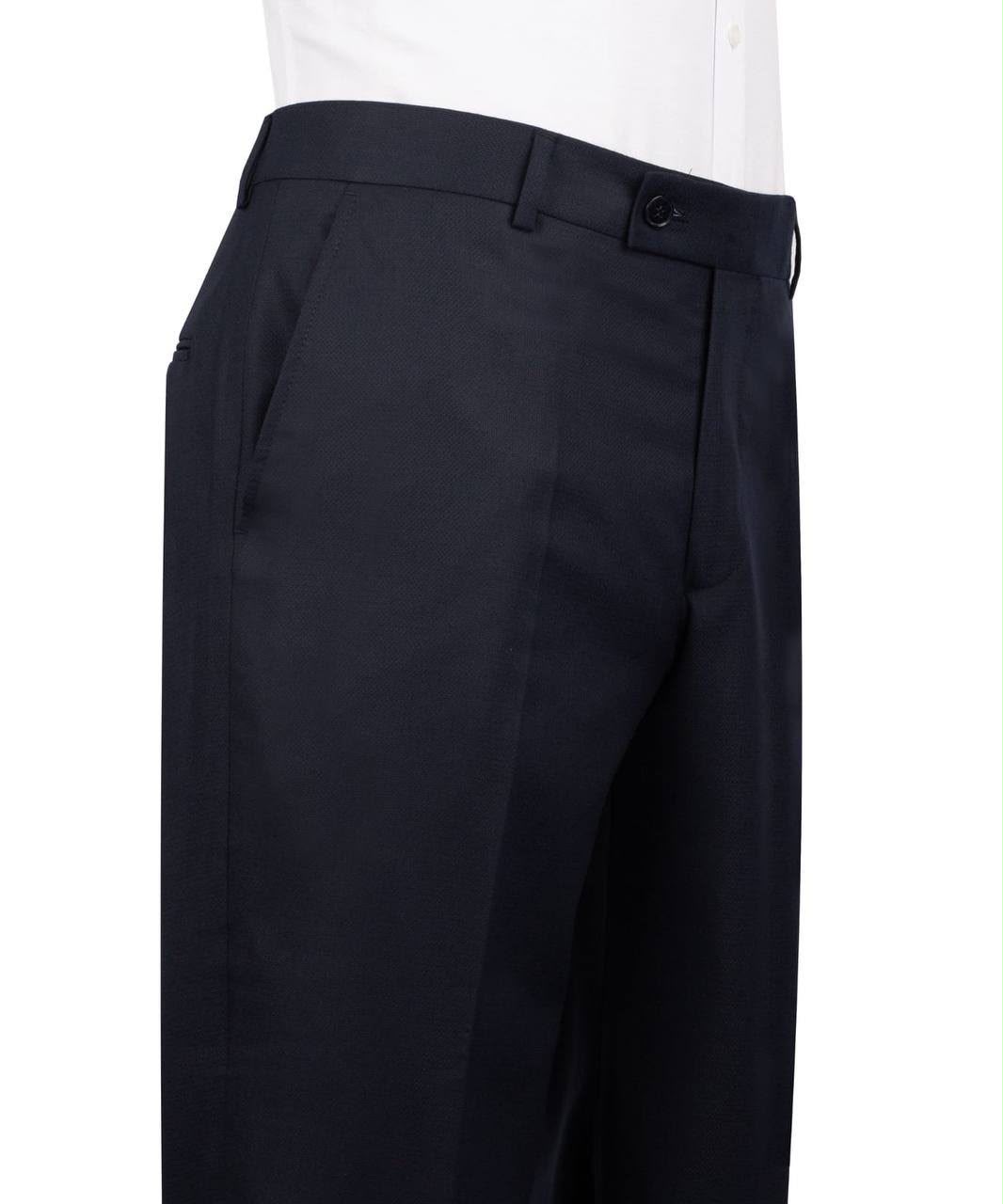 Close-up of a person wearing dark navy tailored trousers with a white shirt visible at the top, photographed against a plain white background.