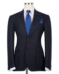 A dark navy blue suit jacket displayed on a mannequin torso, styled with a white dress shirt, a blue patterned tie, and a matching blue patterned pocket square against a plain white background.