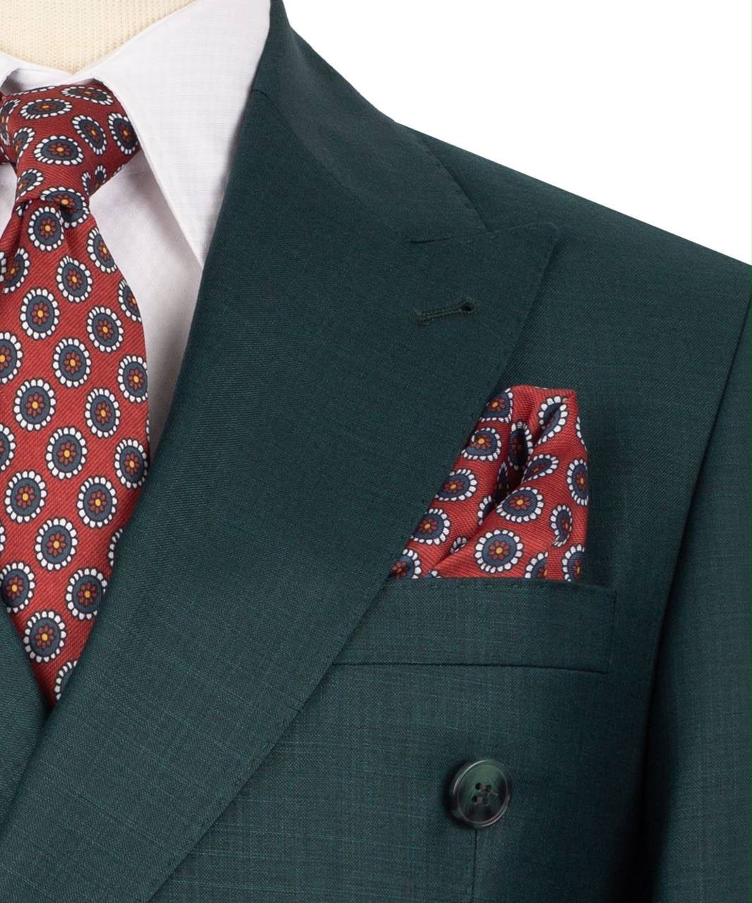 Green suit jacket with a red patterned tie and pocket square on a white background