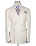 A cream-colored double-breasted suit jacket with subtle vertical pinstripes, displayed on a mannequin torso with a light blue dress shirt, a patterned blue and gold tie, and a matching pocket square.