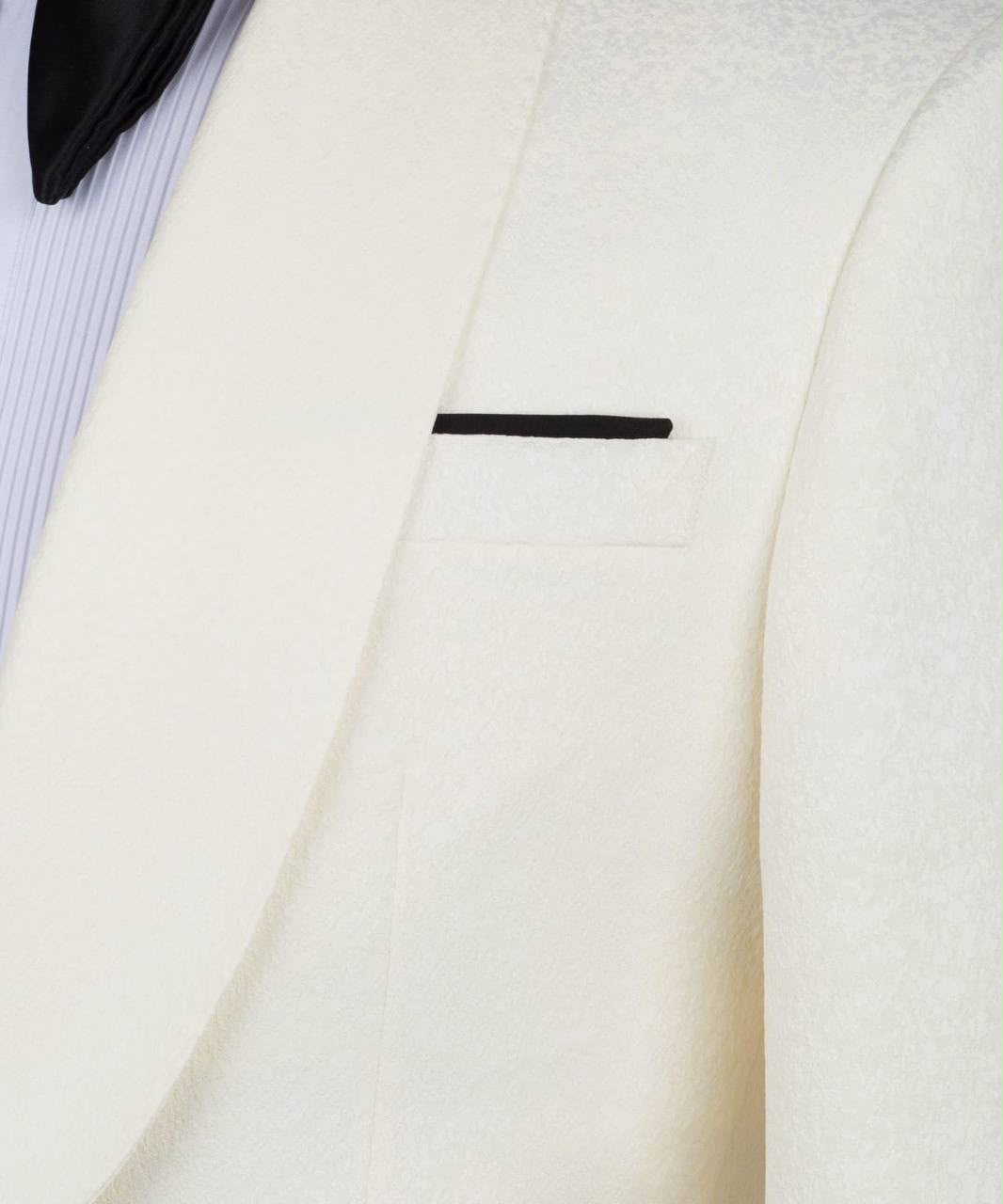 Close-up of a white suit jacket with a black lapel pin 