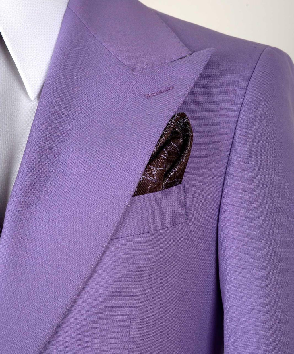 A close-up of a lavender purple suit jacket with a white dress shirt and a patterned brown pocket square in the breast pocket.