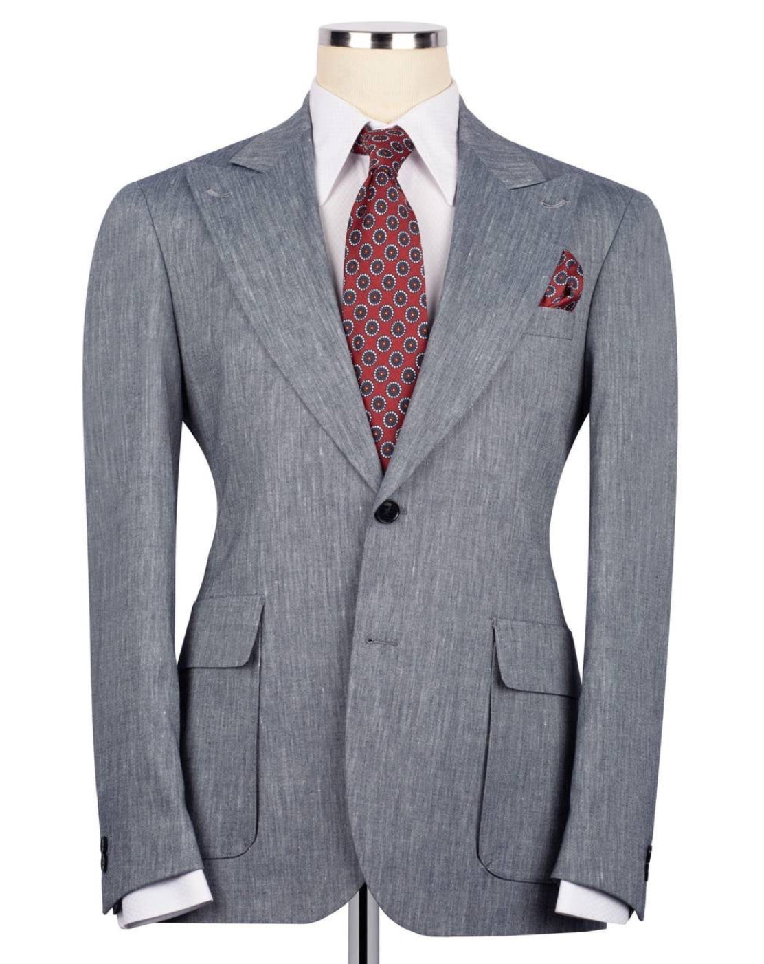 Gray suit jacket with a red patterned tie and pocket square on a mannequin against a white background