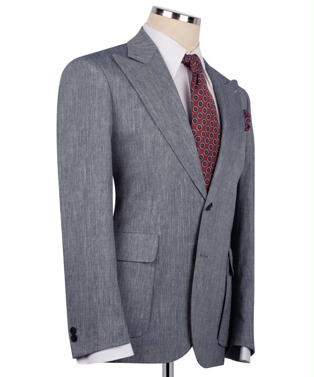 Gray suit jacket with a patterned tie on a mannequin against a white background