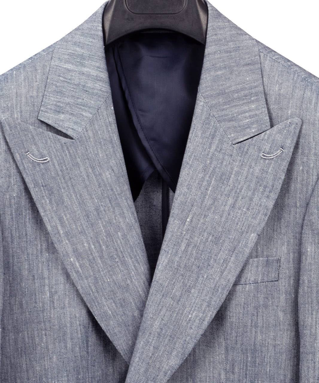 A close-up of a light gray textured suit jacket with notched lapels and a single-breasted front, shown on a hanger with a dark navy shirt underneath against a white background.