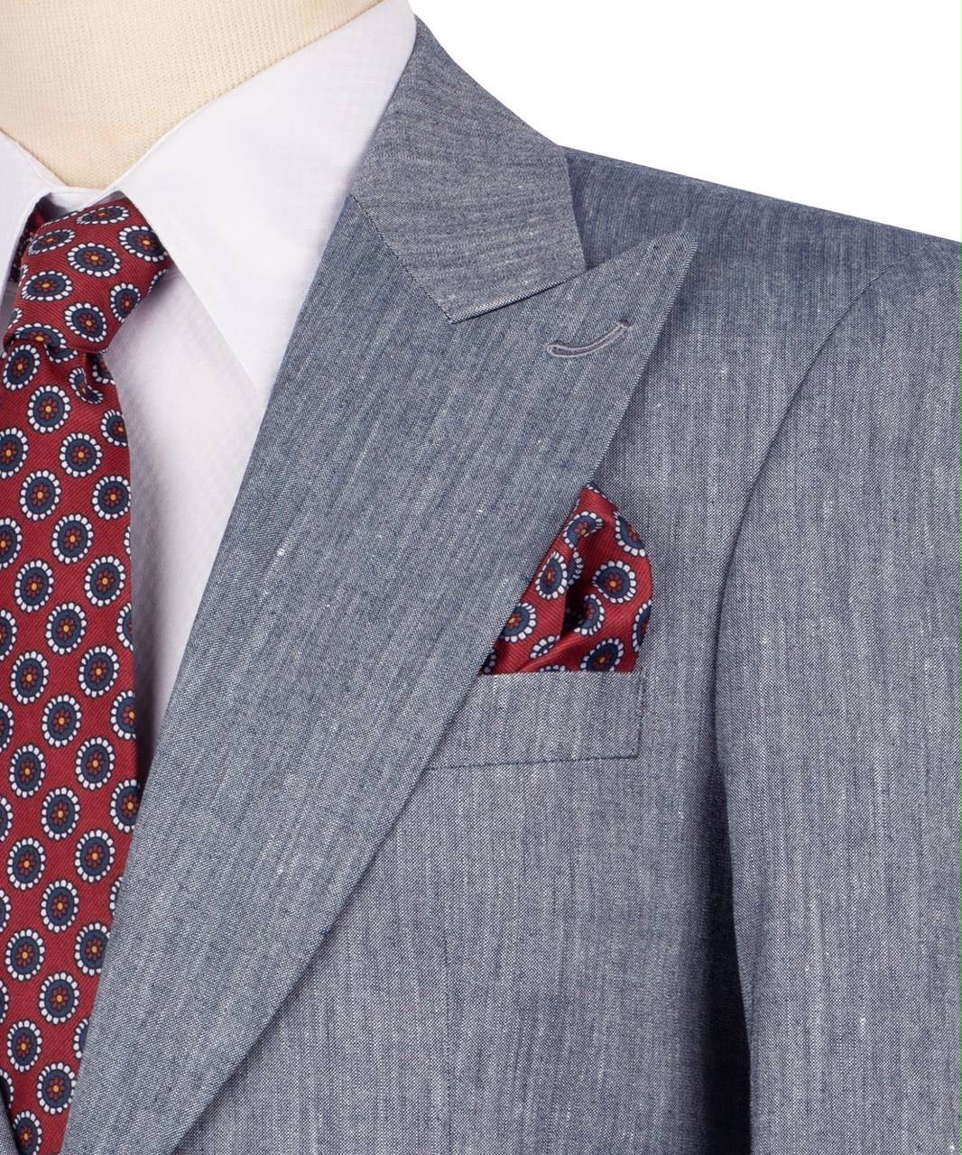 A close-up of a men's gray textured suit jacket on a mannequin, styled with a white dress shirt, a red patterned tie, and a matching red pocket square.