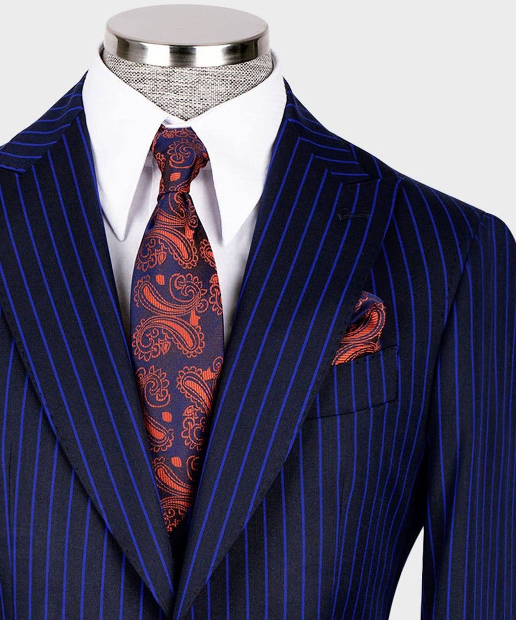 A men's navy blue pinstripe suit jacket displayed on a mannequin torso, styled with a white dress shirt, a navy and red paisley tie, and a matching pocket square.