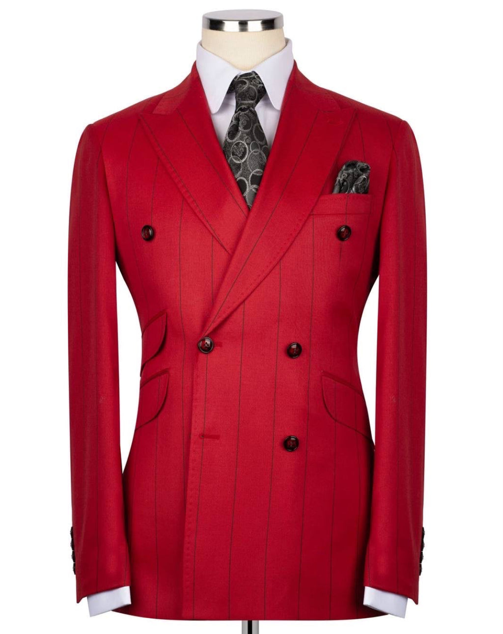 A red double-breasted pinstripe blazer displayed on a mannequin torso, styled with a white dress shirt, a dark patterned tie, and a matching pocket square 