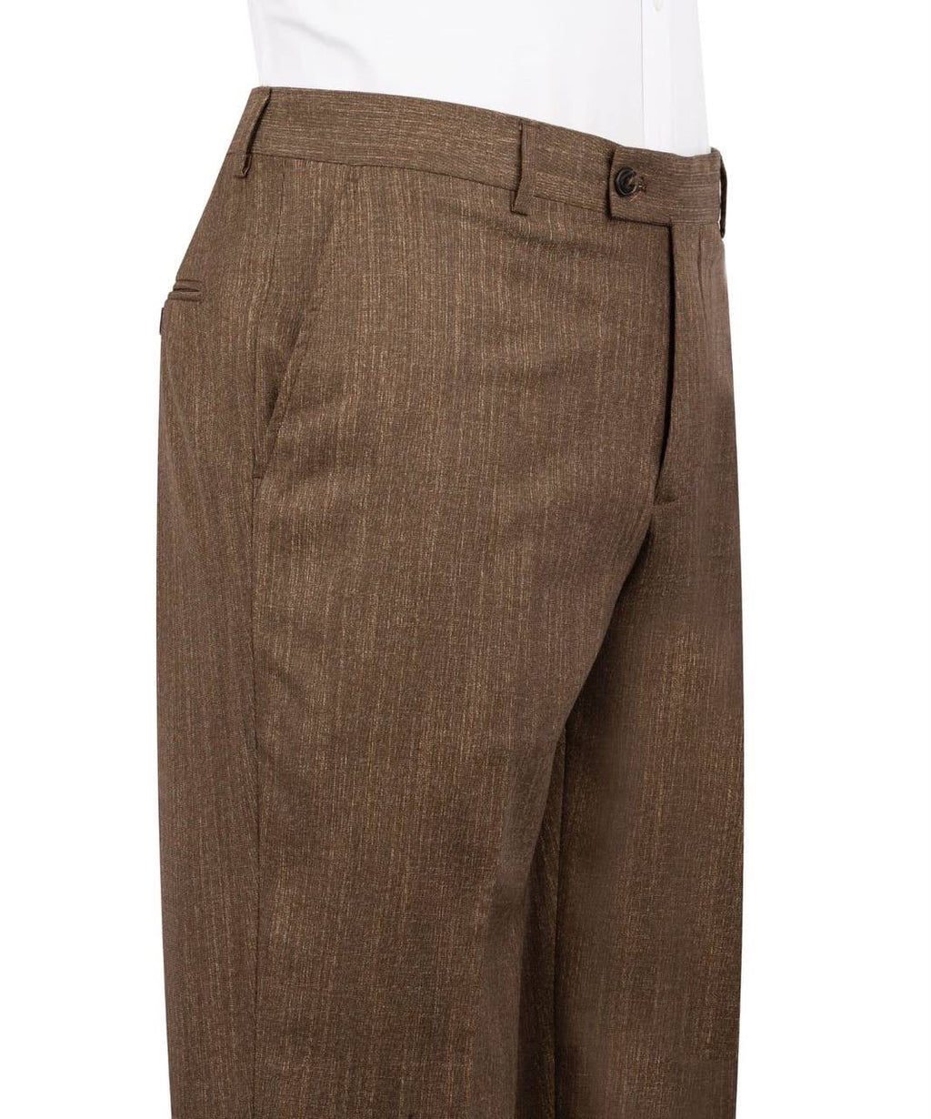 A close-up side view of a person wearing brown textured trousers with a white shirt visible at the waistband, against a plain white background.