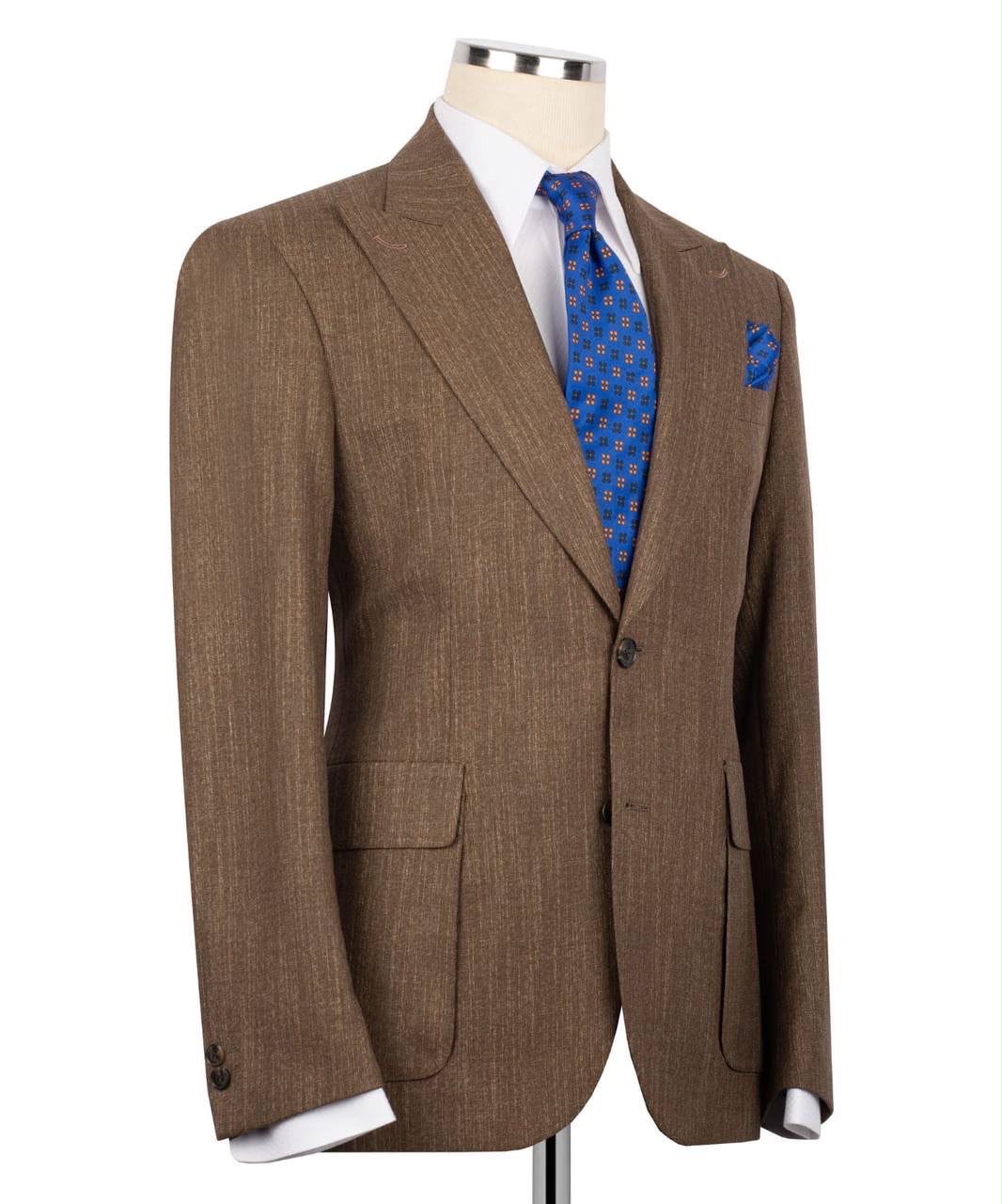 A brown textured suit jacket displayed on a mannequin torso, styled with a white dress shirt, a blue patterned tie, and a matching blue pocket square against a plain white background.