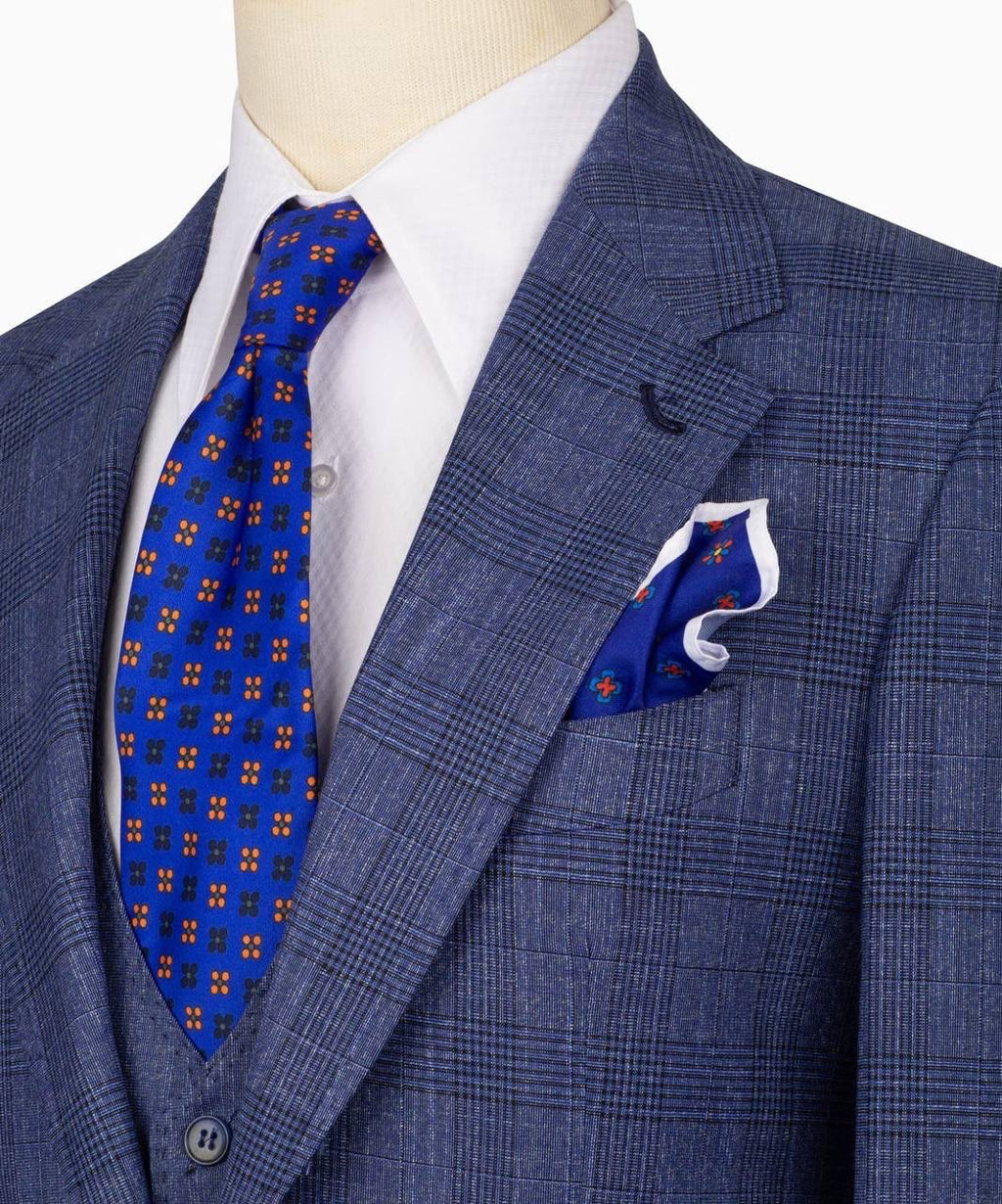 Blue checkered suit with a patterned tie and pocket square on a mannequin.