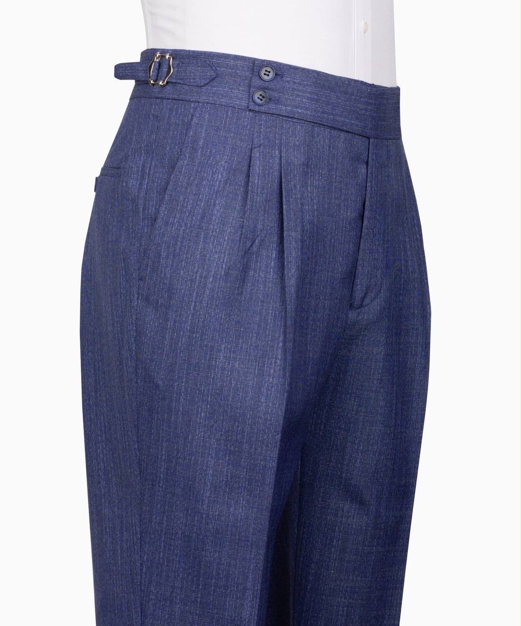Close-up of a pair of blue pleated trousers with a matching belt featuring a gold buckle, shown on a white mannequin torso 