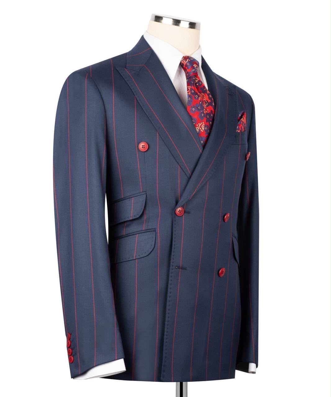A navy blue double-breasted pinstripe suit jacket displayed on a mannequin torso, styled with a white dress shirt, a red and blue floral patterned tie, and a matching pocket square.