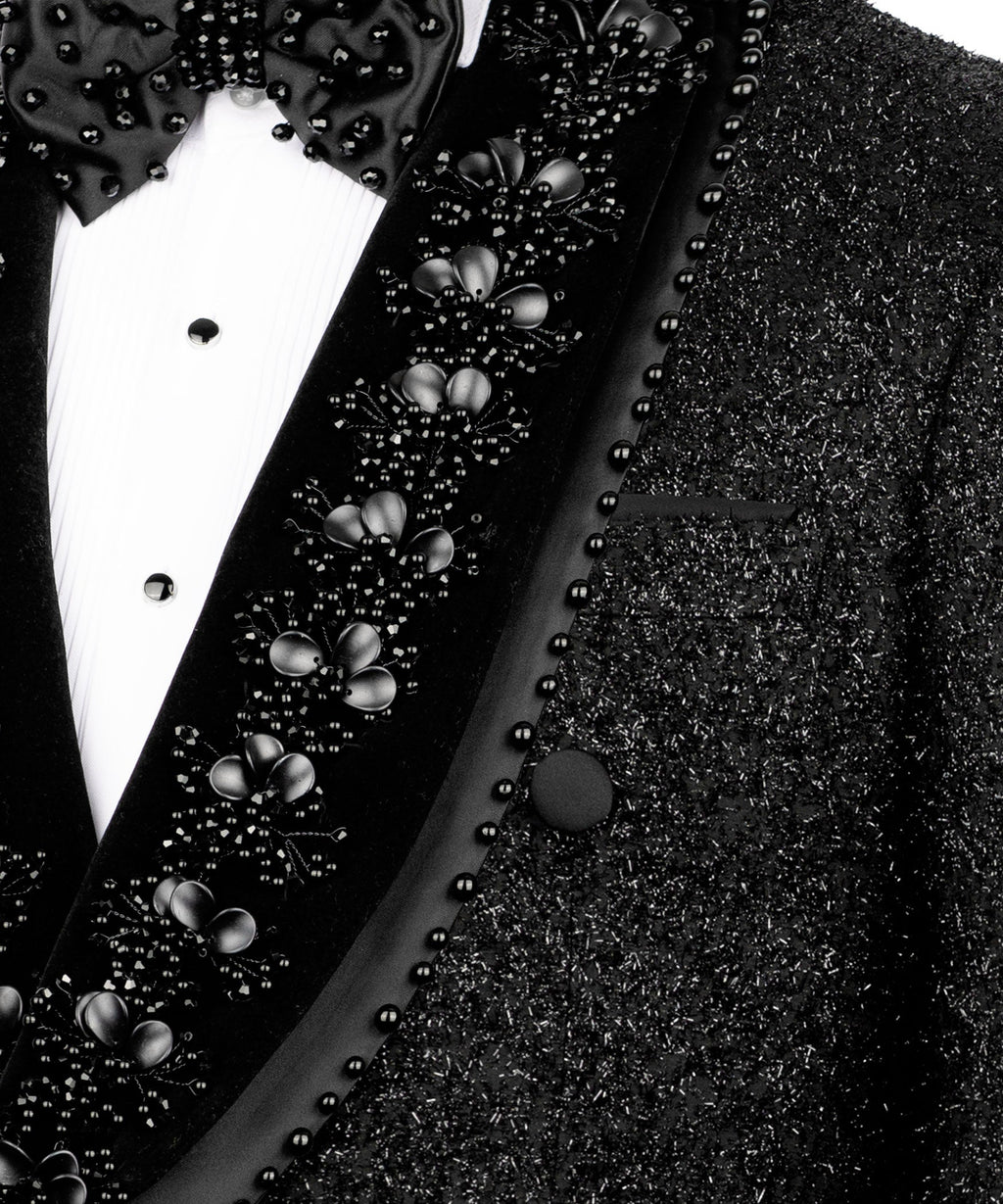 Close-up of stone-beaded bow tie and embellished tuxedo lapel on black blazer