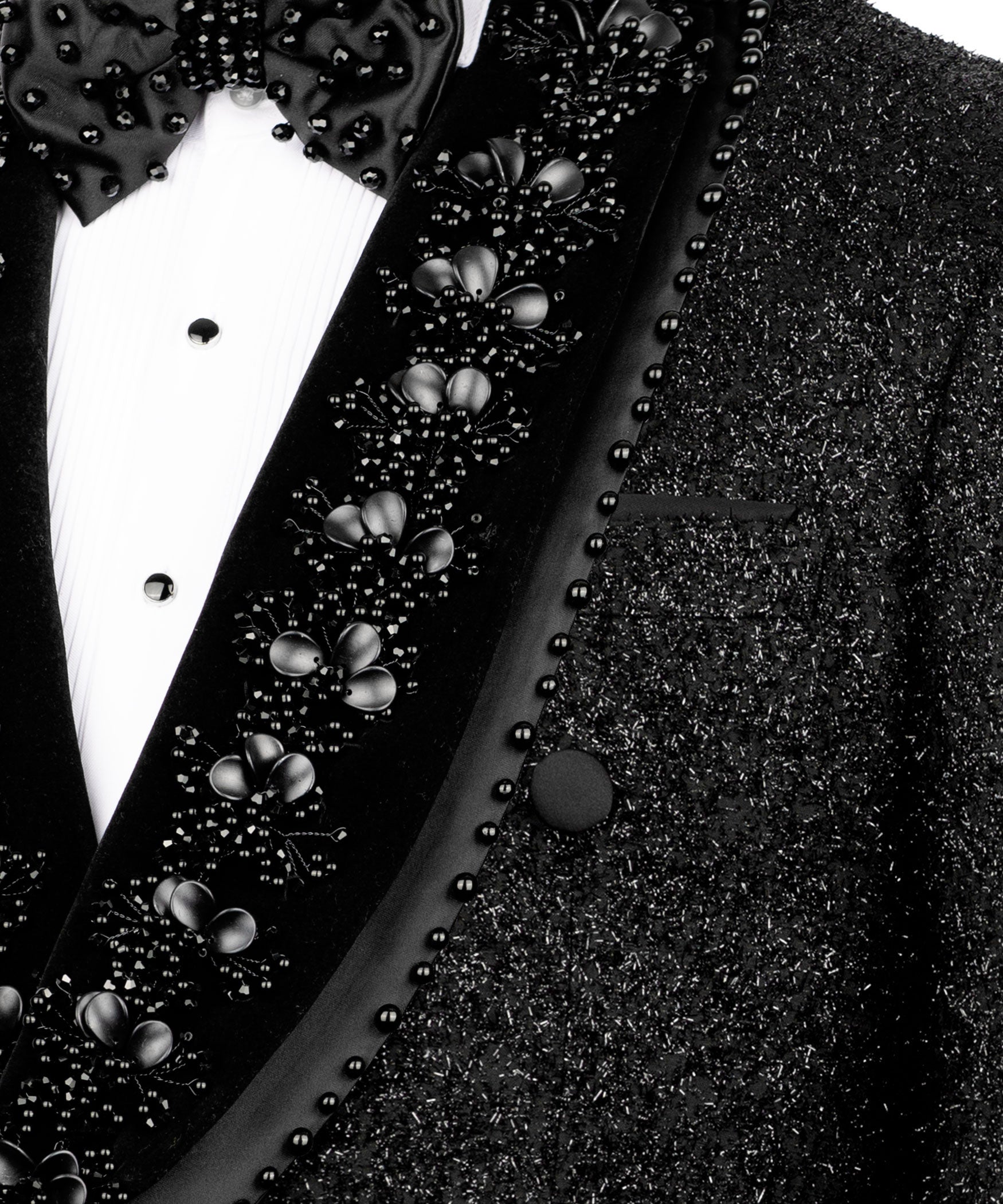 Close-up of stone-beaded bow tie and embellished tuxedo lapel on black blazer