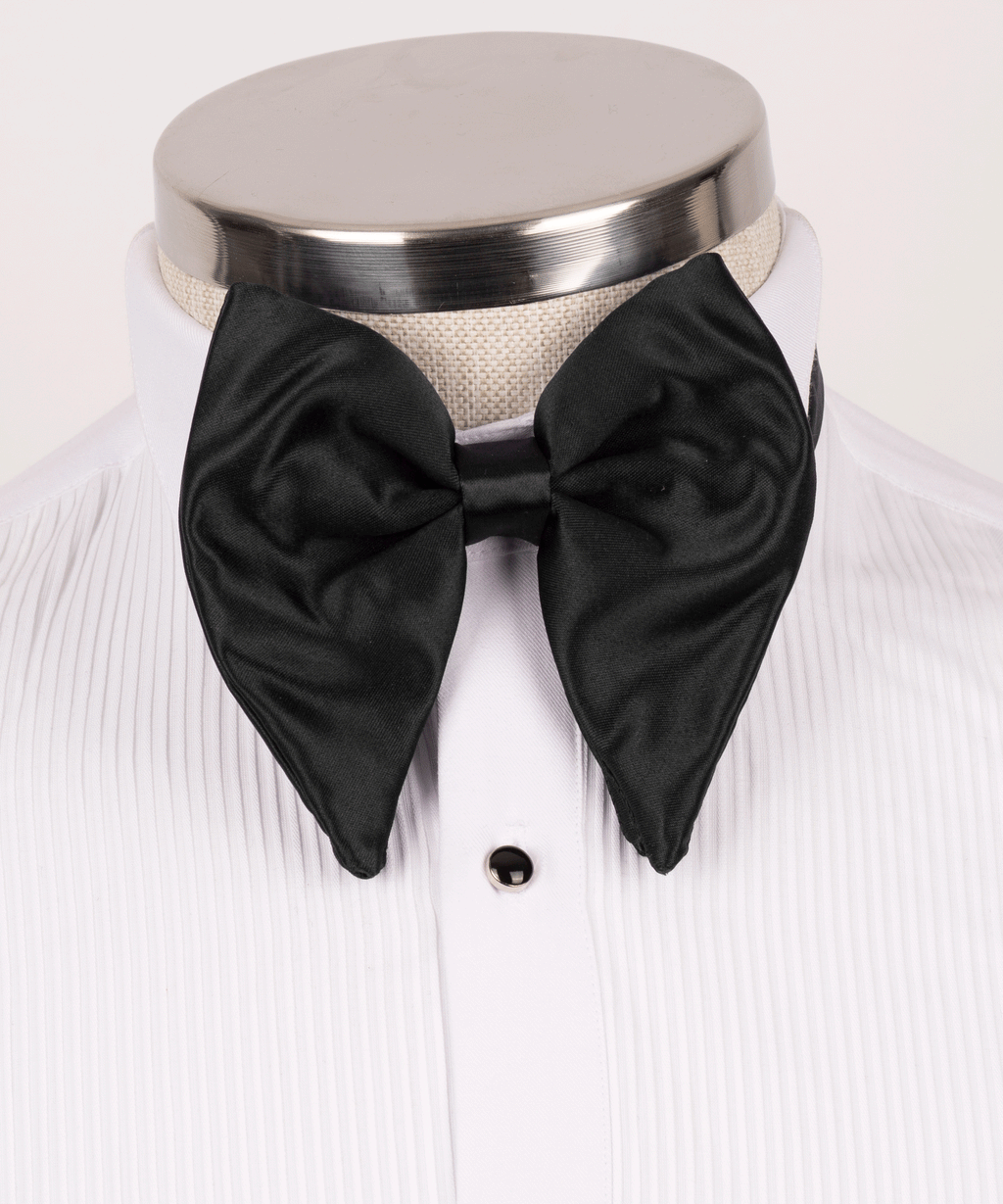 Black satin bow tie on white dress shirt front with single dark button