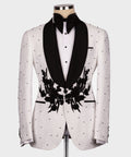 White tuxedo jacket with black lapels and floral appliqué, black bow tie and white shirt