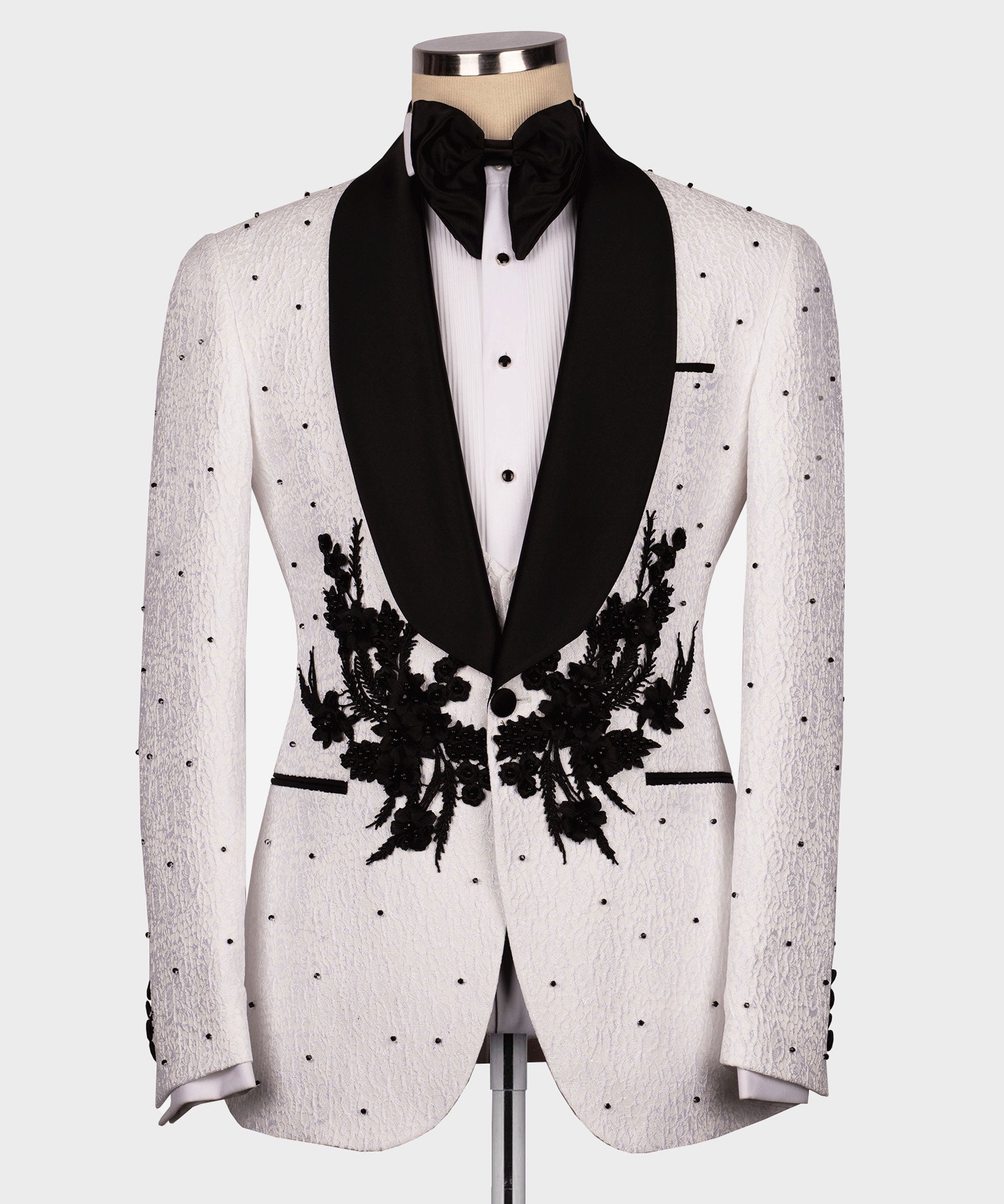 White tuxedo jacket with black lapels and floral appliqué, black bow tie and white shirt