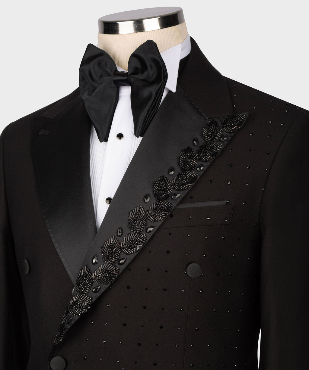 Black tuxedo close-up: bow tie and satin lapel with ornate patterned trim on waistcoat