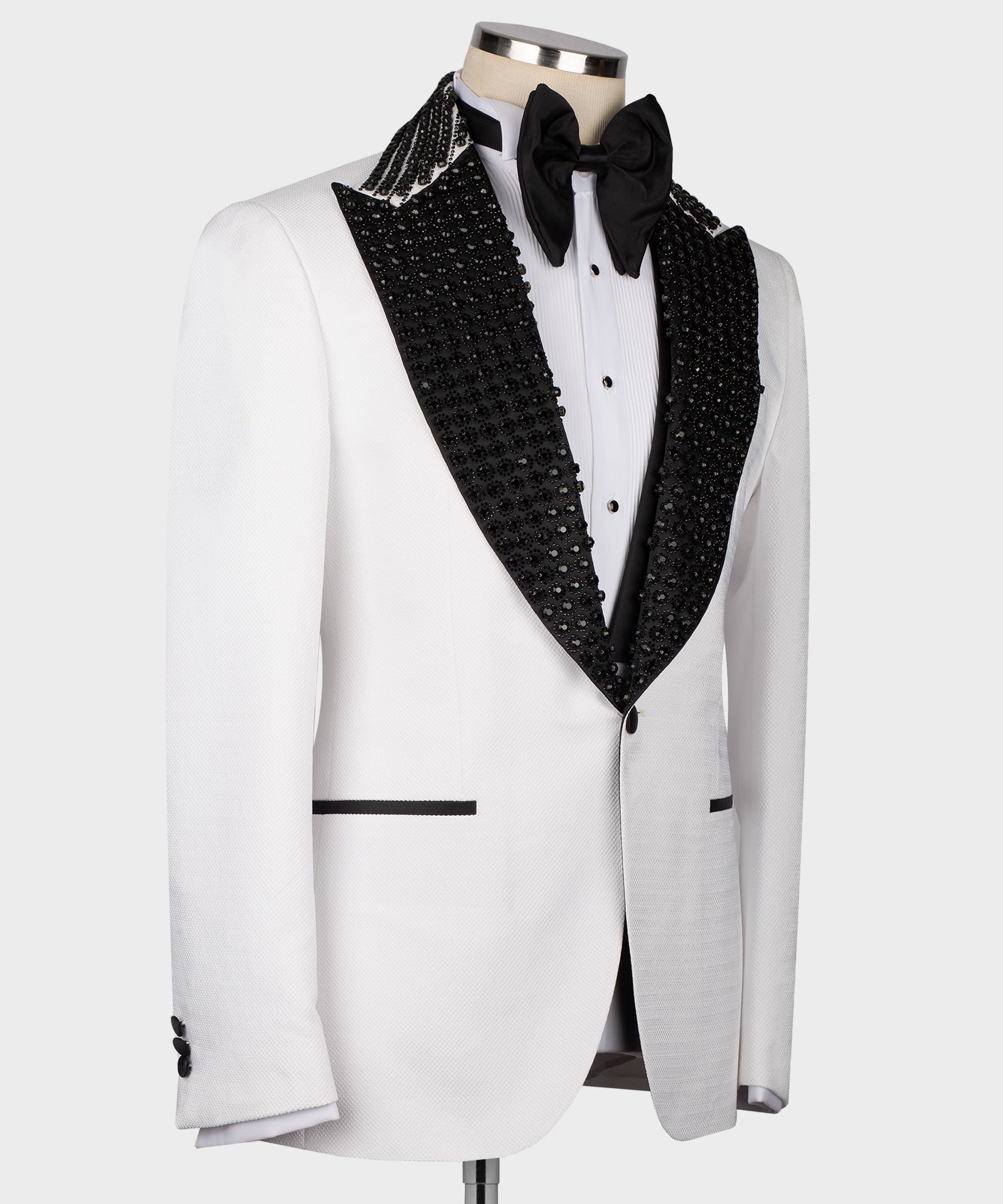White tuxedo jacket with black lapel trim, bow tie, and three-button vest