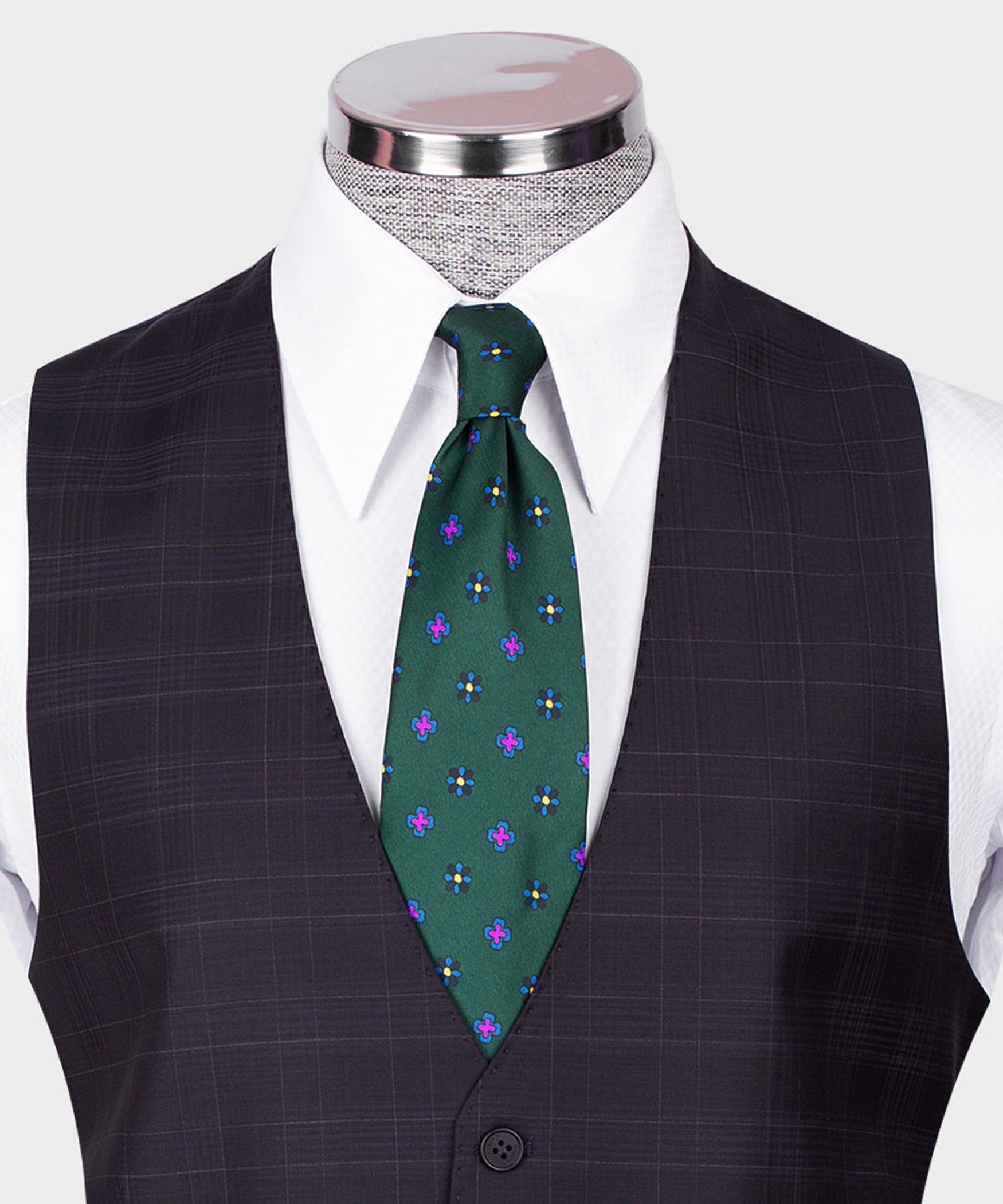 Close-up navy plaid vest with white collar and green patterned tie, button front