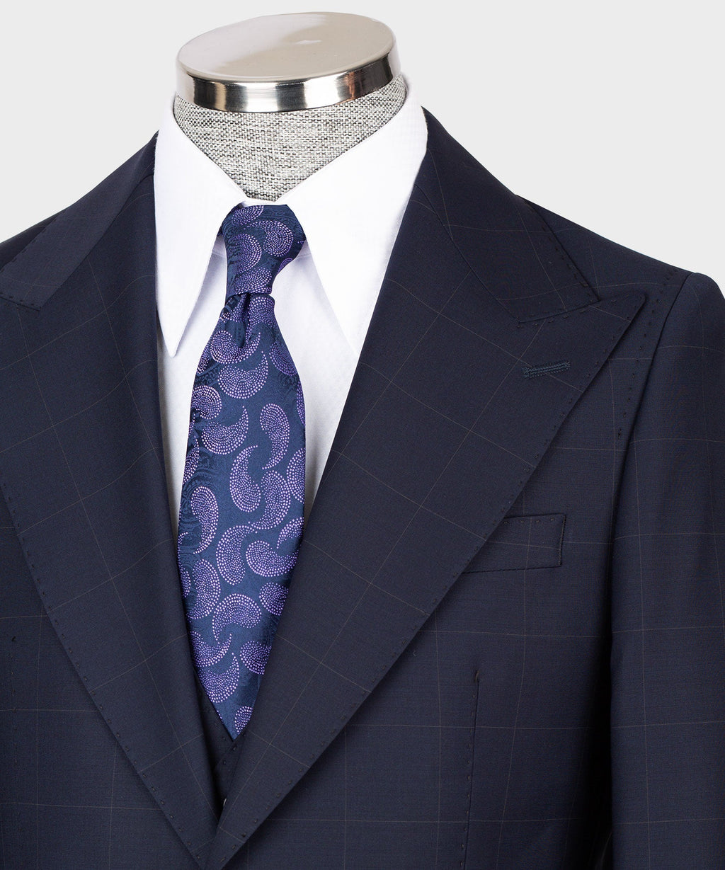 Navy suit jacket lapels and vest, blue-purple patterned tie, white shirt