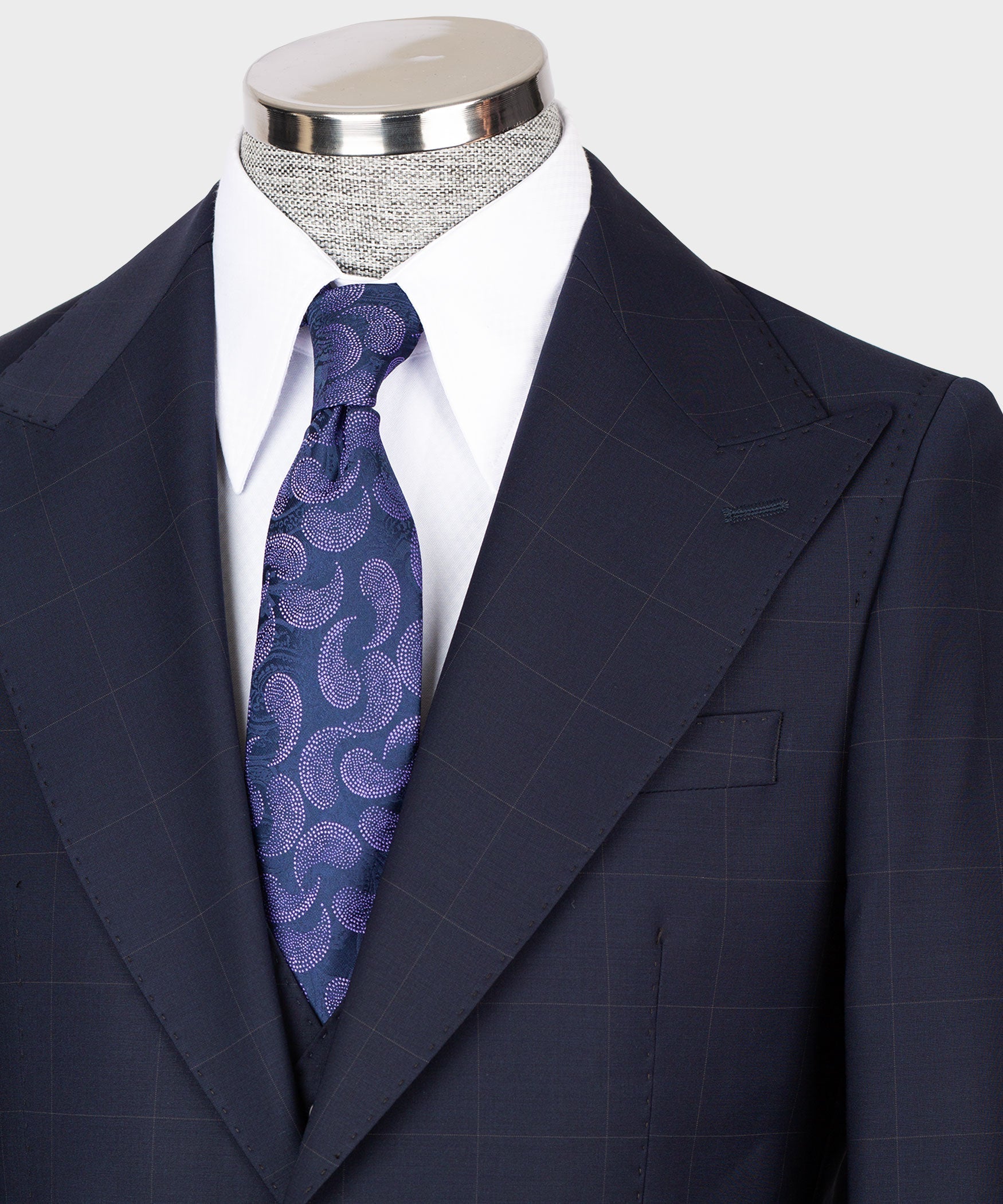 Navy suit jacket lapels and vest, blue-purple patterned tie, white shirt