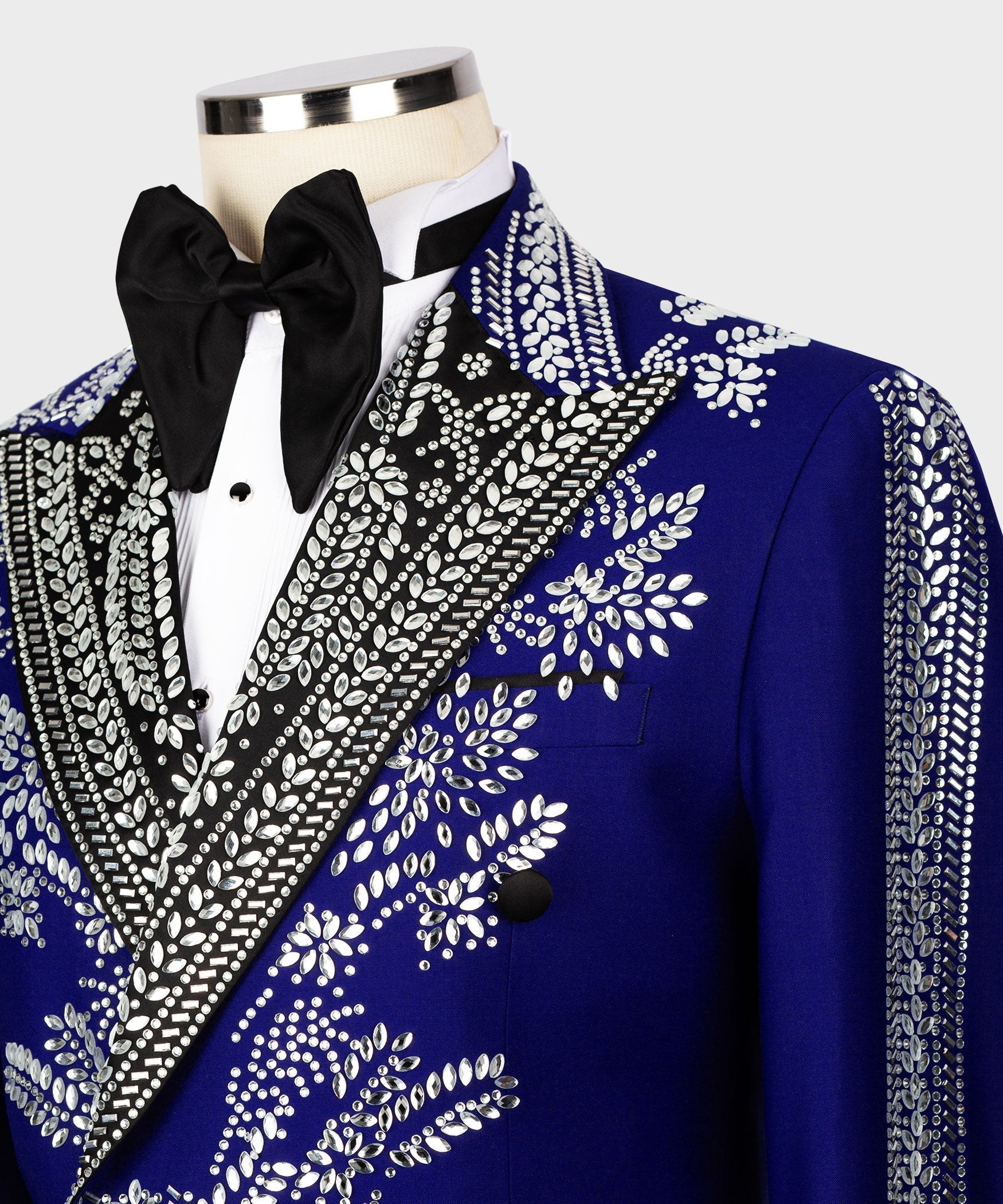 Close-up of blue tuxedo jacket lapel with silver stone embroidery and black bow tie