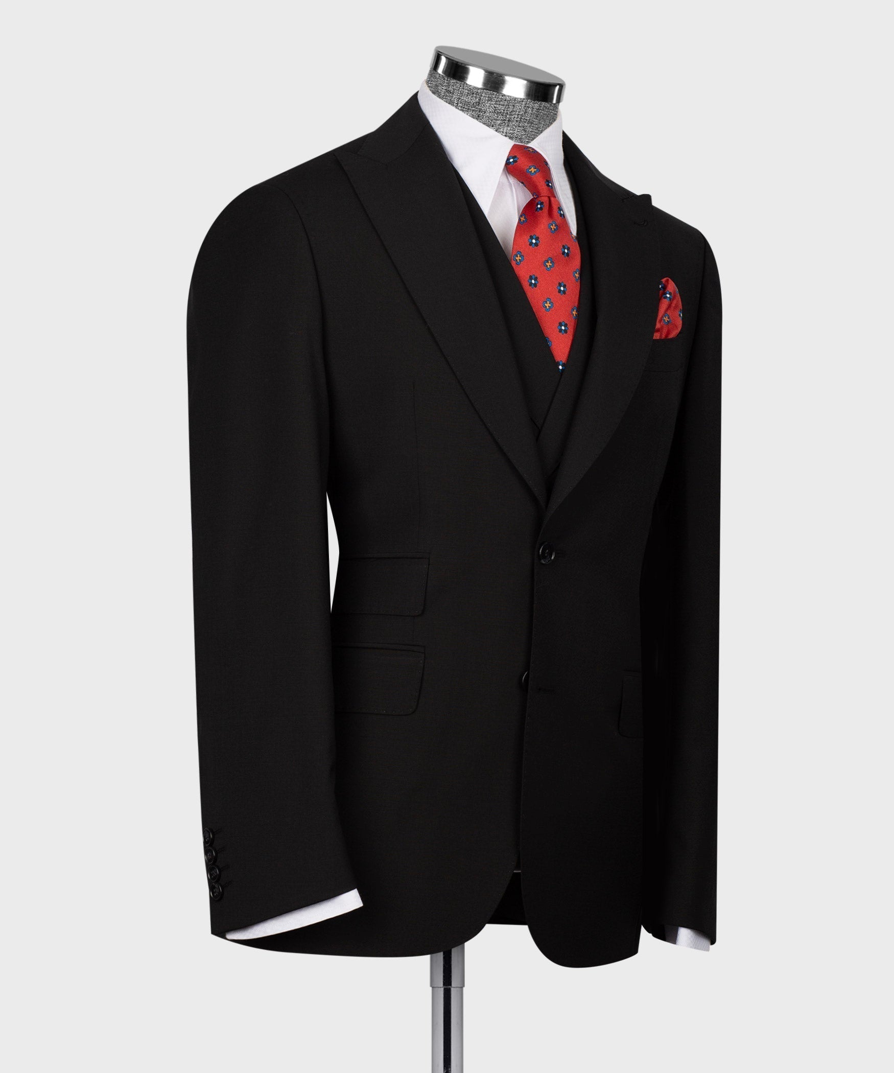 Black 3-piece vest suit on mannequin, red patterned tie and pocket square.