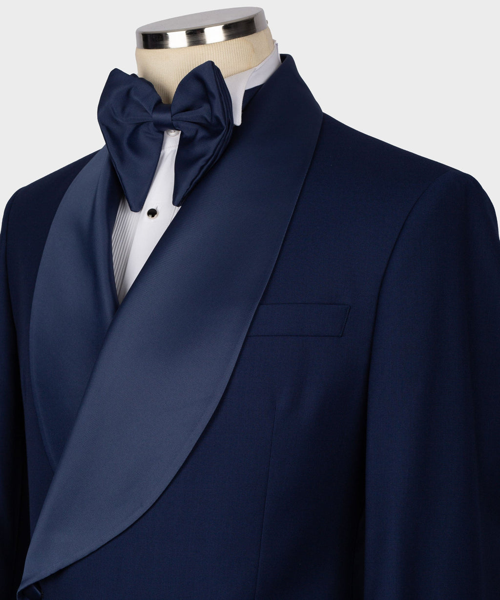 Navy tuxedo lapel with large satin bow tie over white dress shirt, vest